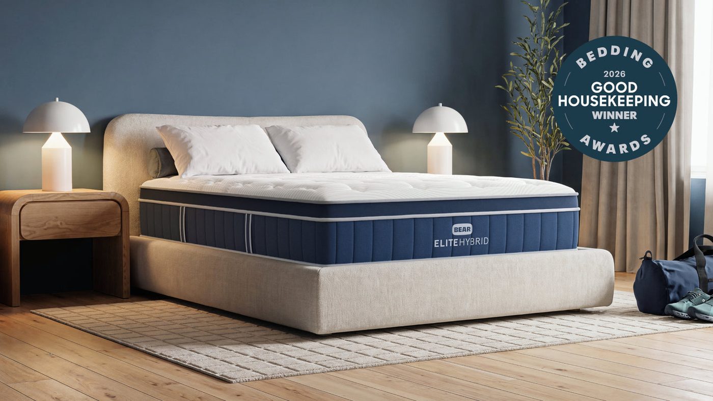 Bear Elite Hybrid mattress styled in a bedroom with navy upholstery
