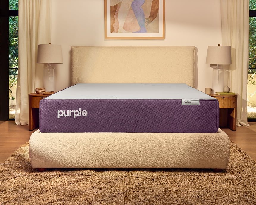 Purple Restore Hybrid mattress styled on a low platform bed